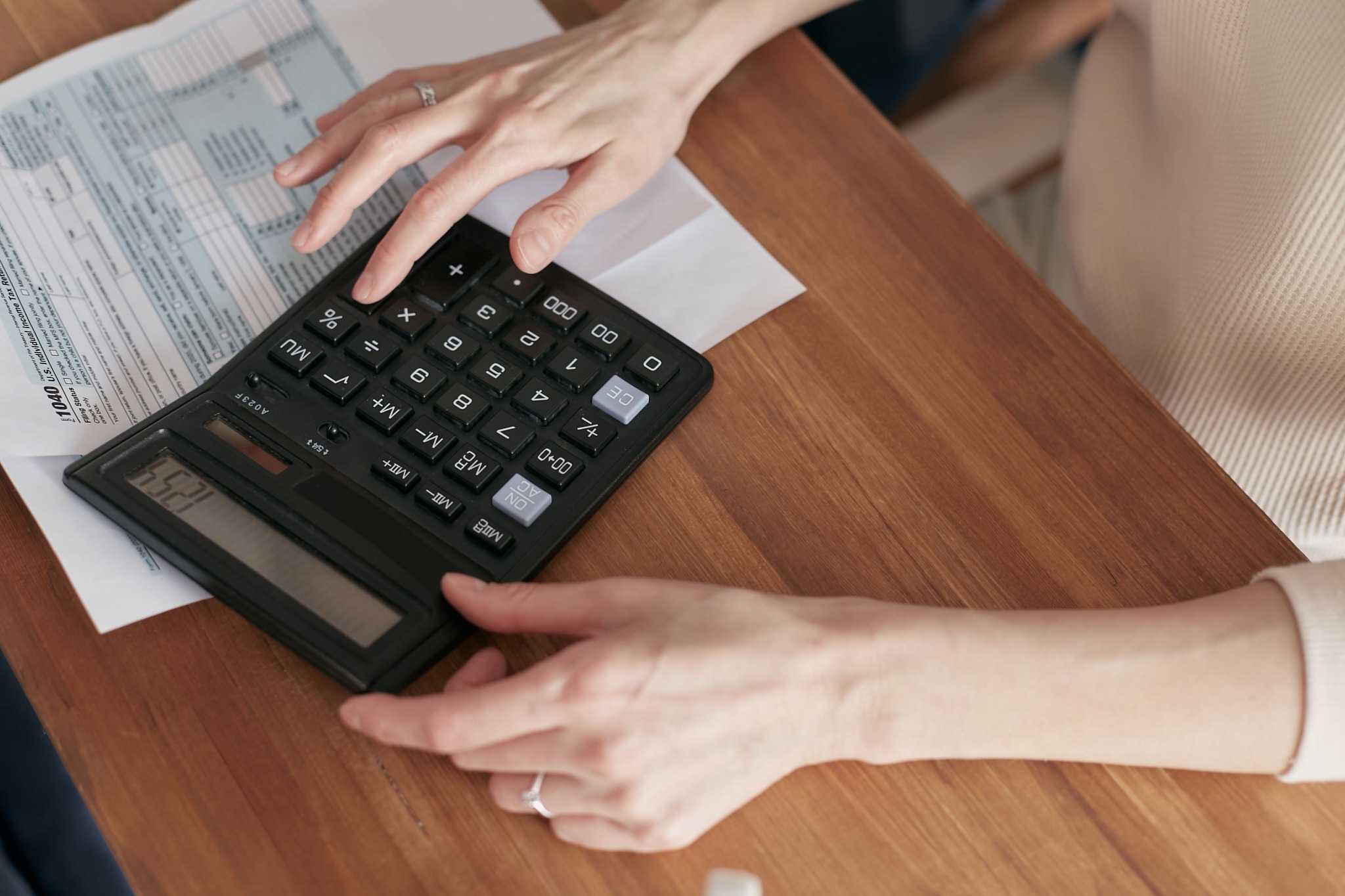 Close-up of calculator and financial paperwork on a wooden table